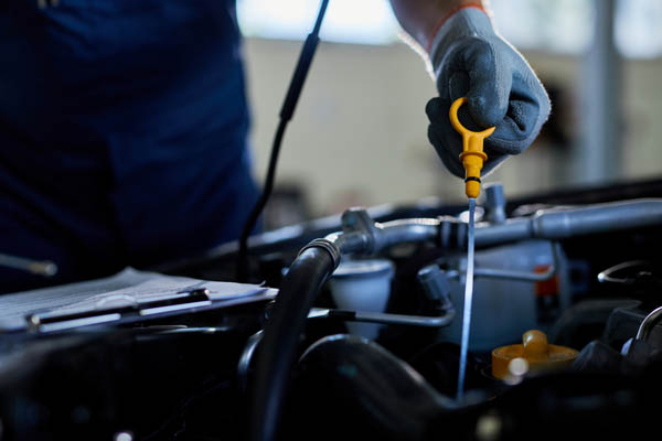 Close Up Of A Auto Repairman Checking Car Oil In A Workshop. Imagen de Close Up Of A Auto Repairman Checking Car Oil In A Workshop.